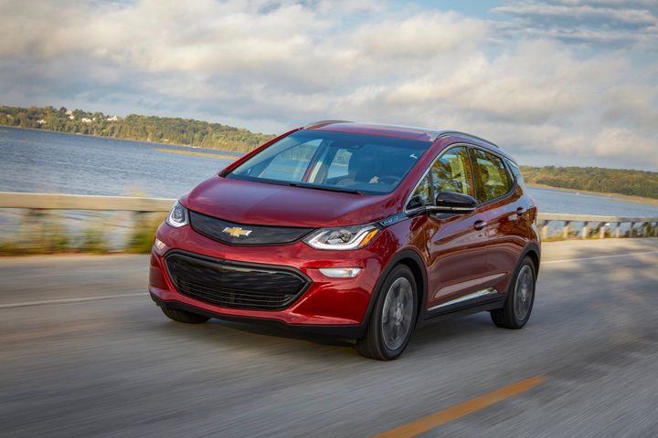 Chevrolet Bolt EV de color granate en una carretera