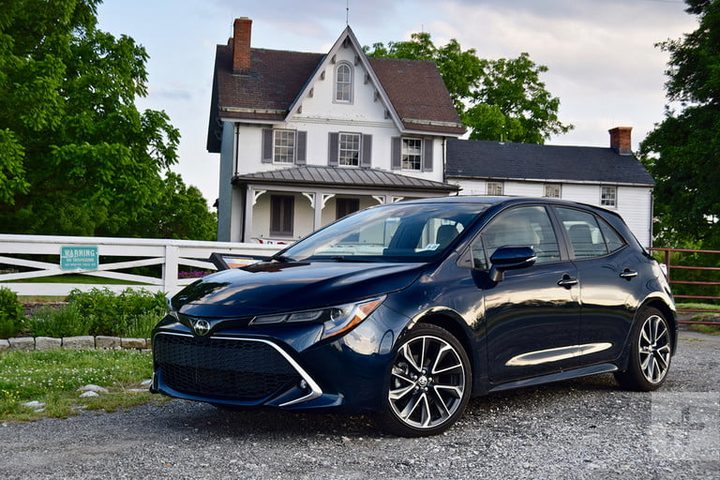 Toyota Corolla Hatchback, uno de los mejores hatchback, de color negro, aparcado delante de una casa.