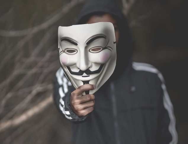 Una persona mostrando la máscara de Guy Fawkes.