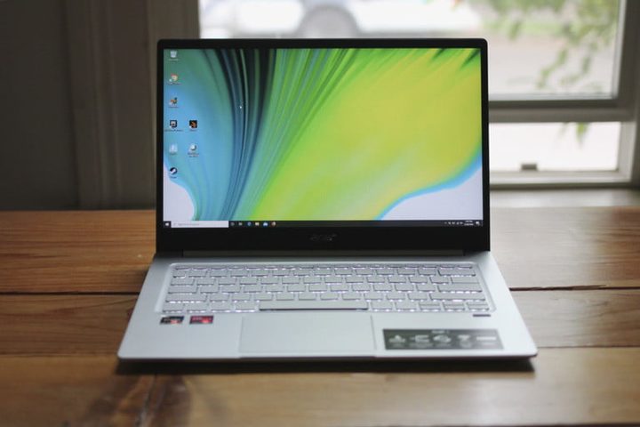 una laptop fina plateada abierta con la pantalla encendida