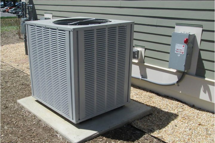 unidad condensadora con forma cuadrada y gris ubicada en el exterior