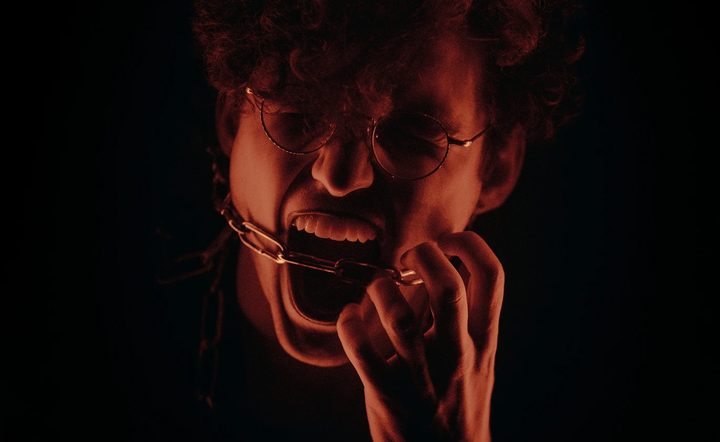Una persona grita con una cadena en sus manos