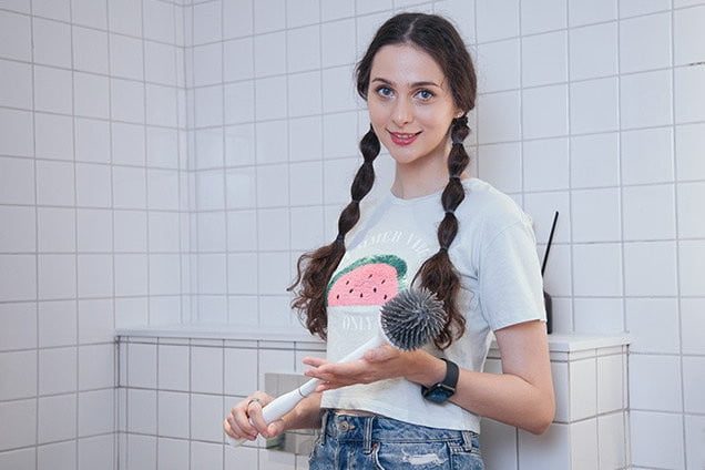 Mujer sostiene el cepillo de baño Good Papa