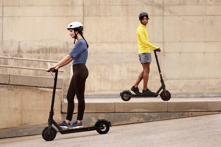 Un chico y una chica subidos a un patinete Xiaomi Mi Electric Scooter Pro 2