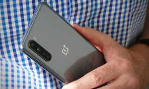 una mano sujeta un OnePlus Nord de color gris visto por la parte trasera