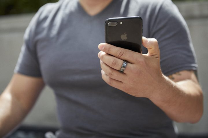 un hombre con el smart ring Ōura Ring puesto, uno de los mejores smart rings del momentophone