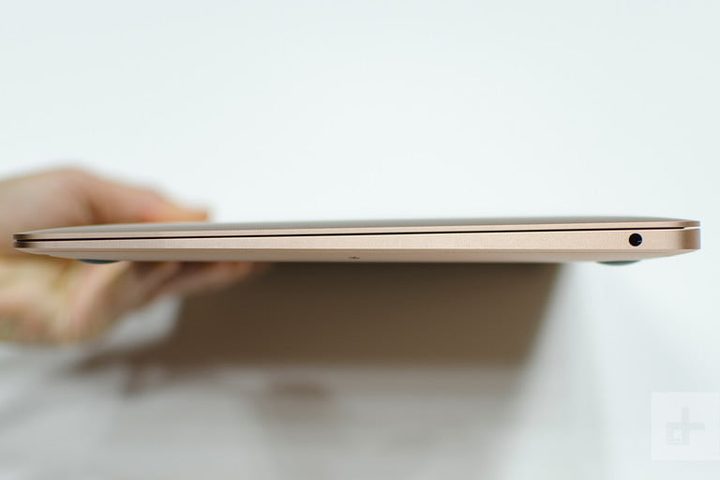 Una mano sosteniendo una MacBook Air vista de lado para comparativo entre Asus ZenBook 14 vs. Apple MacBook Air