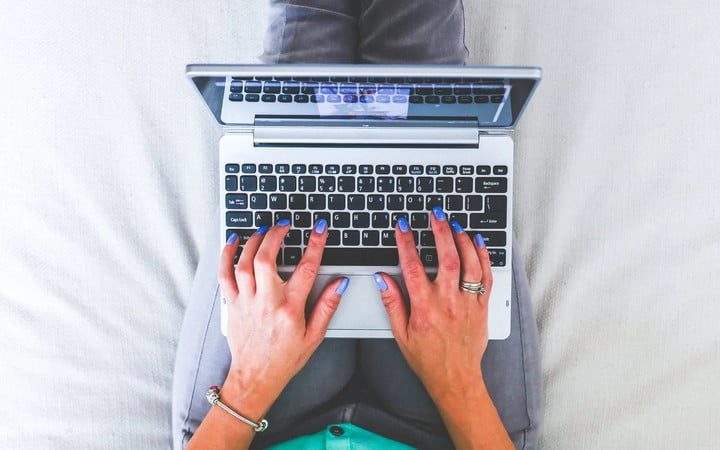 Una persona con su laptop sobre las piernas para aprender a cómo compartir un disco duro