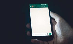 una mano sostiene un teléfono con whatsapp