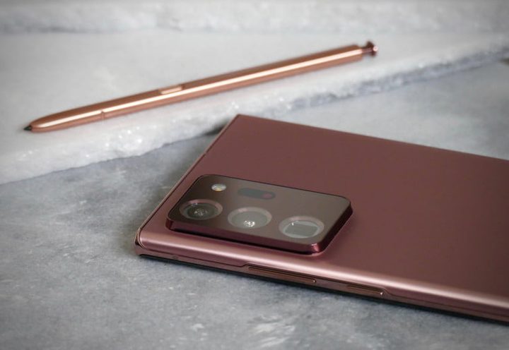 teléfono Galaxy Note 20 junto al S Pen, ambos de color bronce, apoyados sobre una mesa