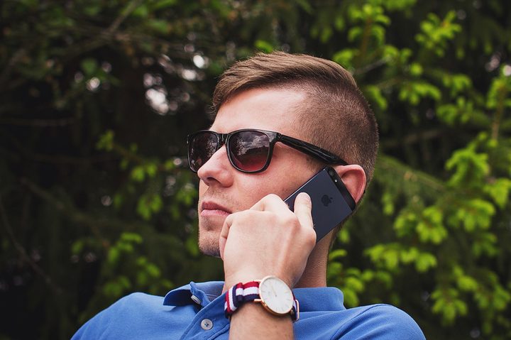 un hombre llama por teléfono para aprender cómo grabar llamadas en un iPhone