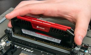 La mano de una persona instalando memoria RAM en una placa base