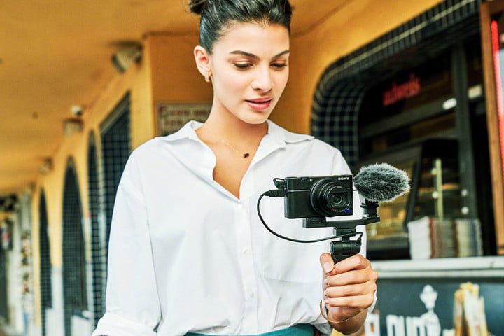 Una mujer con la cámara Sony RX100 VII, una de las mejores video cámaras para 2020, en un pedestal.