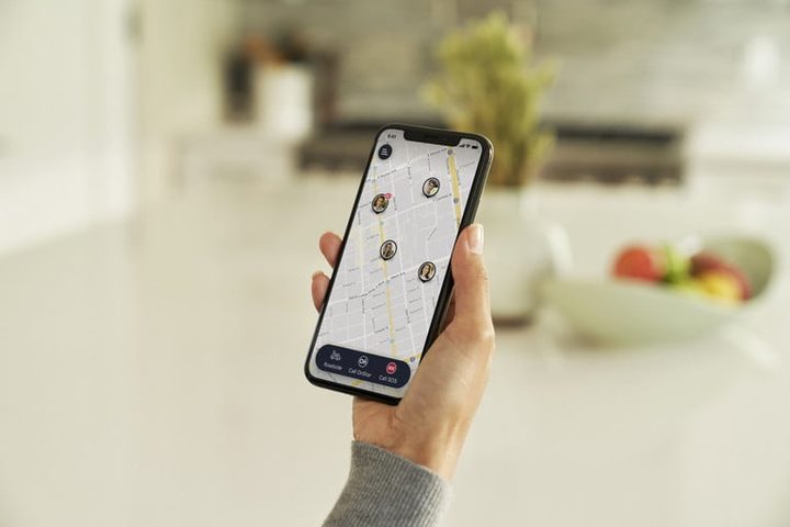 Celular en la mano de una persona con la aplicación para conocer qué es OnStar