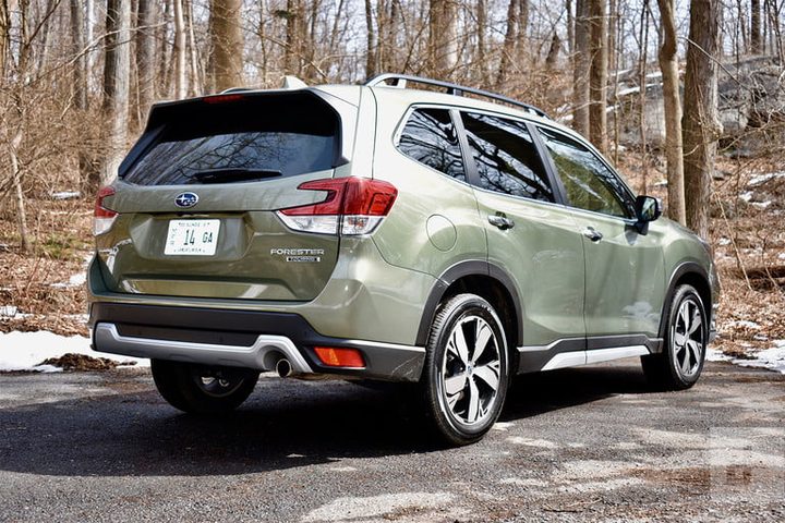 Subaru Forester verde oliva en un bosque para comparar Toyota RAV4 vs. Subaru Forester
