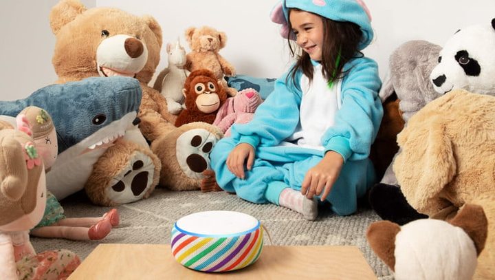 una niña sentada con nueva bocina de colores y muchos peluches alrededor