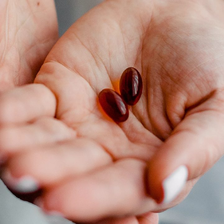 Una persona sostiene cápsulas de ibuprofeno