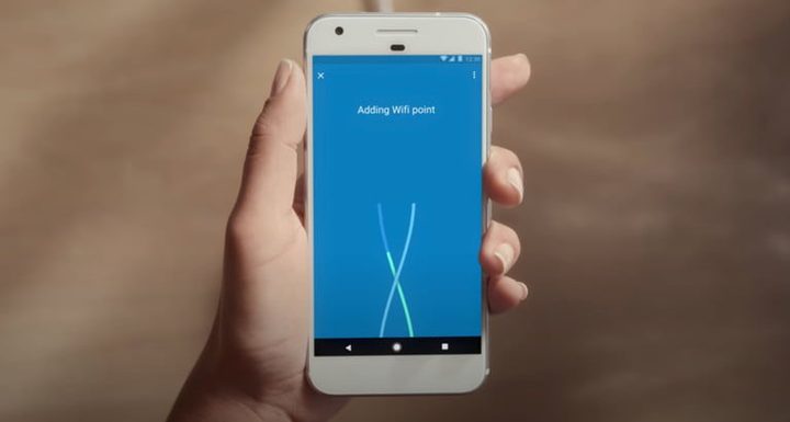 La mano de una persona sosteniendo un celular con la app Google Wifi para comparar Google Wifi vs. Nest Wifi