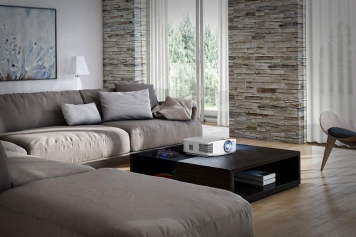 Proyector Optoma UHD50X en una sala sobre una mesa de centro, , uno de los mejores proyectores para cine en casa