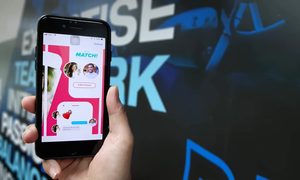 Una persona sostiene un teléfono con la aplicación de Tinder