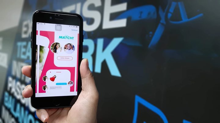 Una persona sostiene un teléfono con la aplicación de Tinder