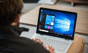 Una persona trabajando en su laptop para aprender cómo descargar Windows 10 ISO