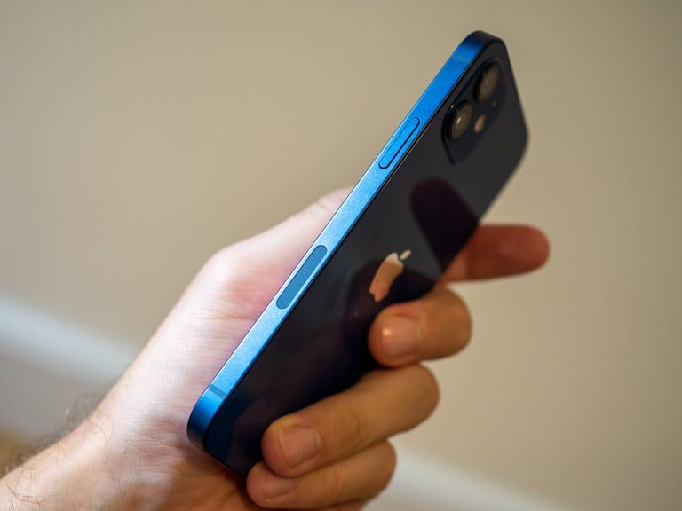 Celular en la mano de una persona para verificar porque el iPhone no aparece en iTunes