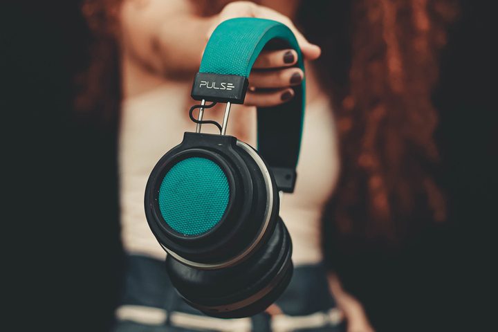 Chica sosteniendo unos audífonos