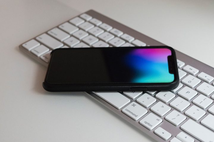 Celular sobre un teclado para aprender a restaurar contactos desde iCloud