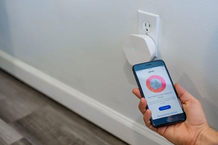Una mano sosteniendo un celular para configurar xFi Pod Xfinity con su aplicación