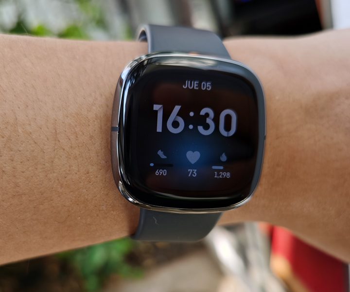 Usuario enseñando el Fitbit Sense