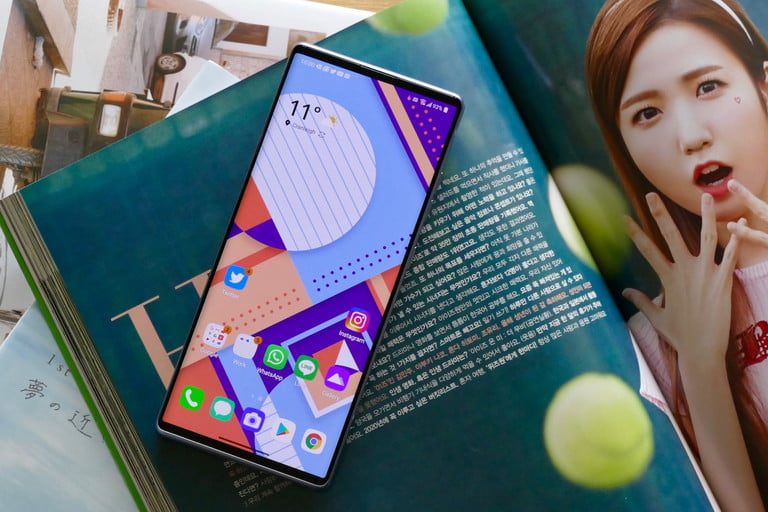 Teléfono LG WIng sobre una carpeta y una chica a un lado