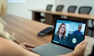 Una persona con su laptop en videollamada tratando de resolver problemas con Microsoft Teams