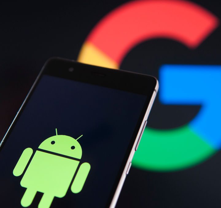 La imagen muestra en primer plano un celular con el logo de Android.