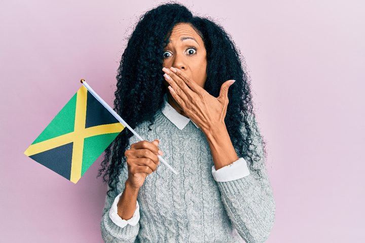 Una mujer con la bandera de Jamaica hace un gesto de sorpresa