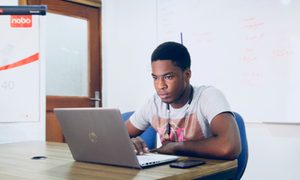 Un hombre sentado frente a su laptop aprendiendo a editar varias fotos a la vez