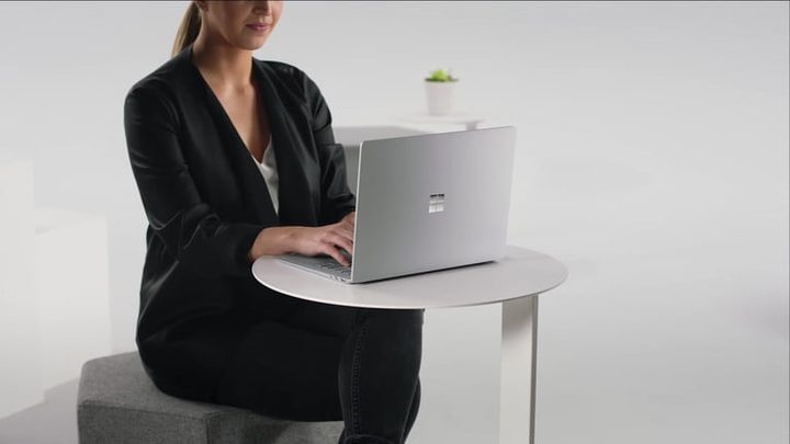 Una mujer con su laptop investigando cuánto cuesta Microsoft Office