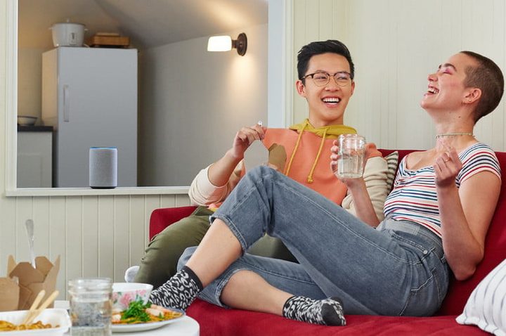 Dos personas en un sofá disfrutando la música y comparando el Amazon Echo Plus 1 vs. Echo Plus 2