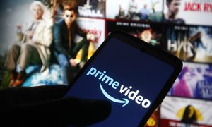 Una persona sostiene un teléfono inteligente con el logo de Amazon Prime Video