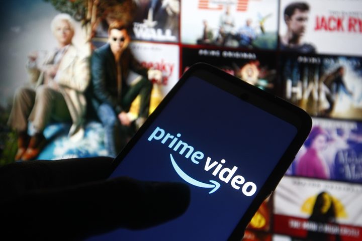 Una persona sostiene un teléfono inteligente con el logo de Amazon Prime Video