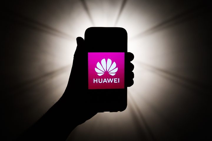 una persona sostiene un teléfono Hauwei con un fondo negro detrás