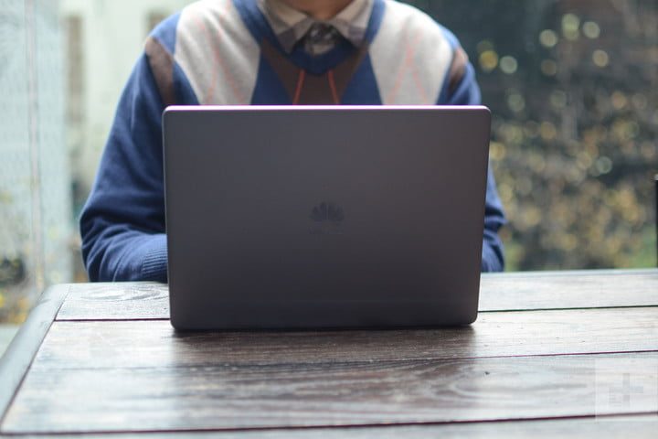 Un hombre sentado trabajando sobre su laptop en una mesa para comparar Apple MacBook Air (2018) vs. Huawei MateBook 13 (2019)