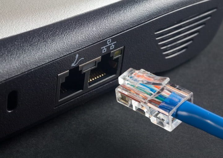 Cable Ethernet azul cerca de ul conector de una laptop