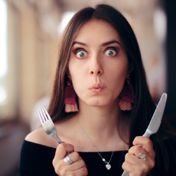 Una mujer con un tenedor y un cuchillo