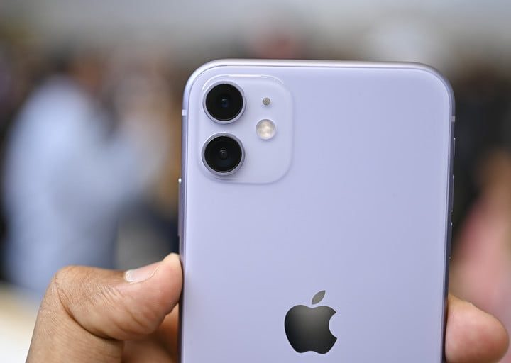 iPhone 11 en la mano de una persona mostrando la parte trasera con sus dos cámaras