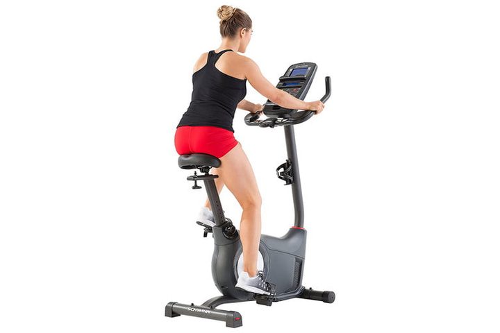 Una mujer montada en una Schwinn Fitness 170 Upright Bike, una de las mejores bicicletas estáticas del mercado