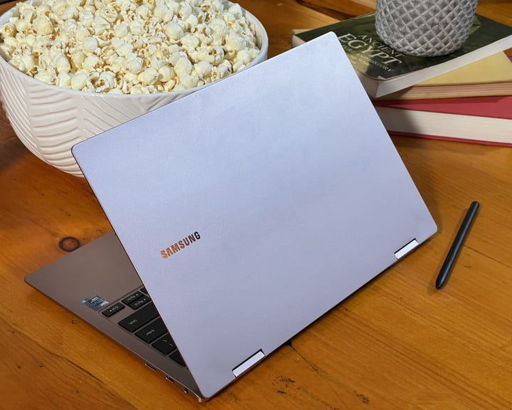 Galaxy Book Pro sobre una mesa junto a libros y un bowl con poalomitas