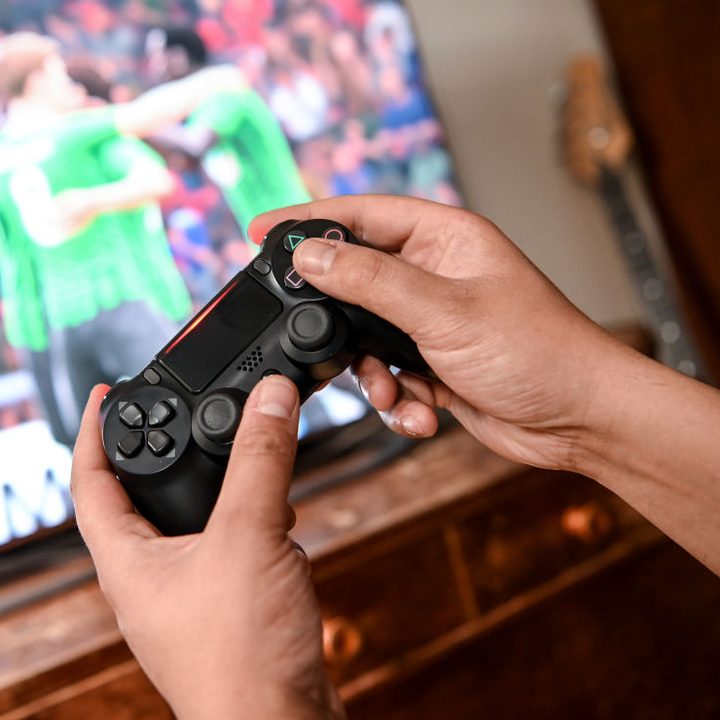 Una persona juega un videojuego de fútbol en PlayStation 4