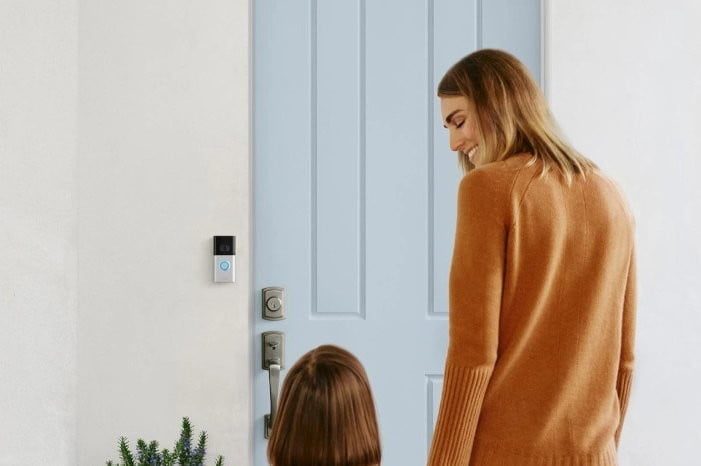 Una mujer y su hija caminando a la puerta principal de una casa protegida con un Ring Video Door, para comparar el Ring Video Doorbell 4 vs. Ring Video Doorbell 3