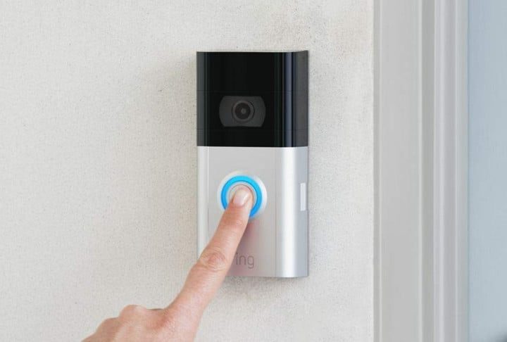 El dedo de una persona presionando el botón de un Ring Video Door